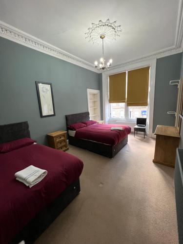 格拉斯哥Sauchiehall Street West End Apartment的一间卧室配有两张床和吊灯。