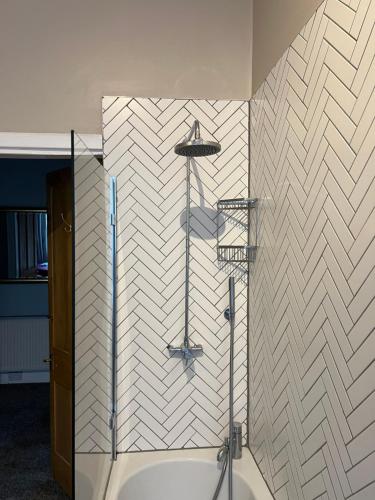 格拉斯哥Sauchiehall Street West End Apartment的一间带淋浴的浴室,铺有白色的瓷砖墙