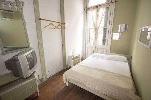 罗萨里奥Hostel Point的一间卧室设有一张床、一台电视和一个窗口。