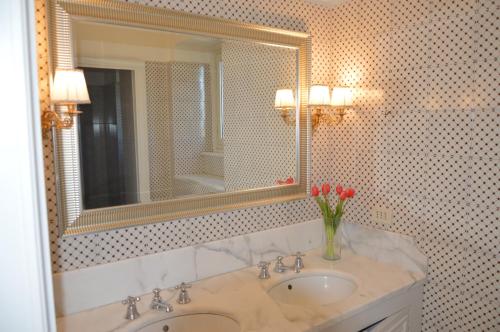 马斯卡卢恰Le stanze dei Mori - quadrupla con bagno privato的浴室设有水槽、镜子和鲜花