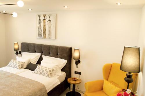 普利特维采湖Afrodita Wellness Essence的一间卧室配有一张床和一张黄色椅子