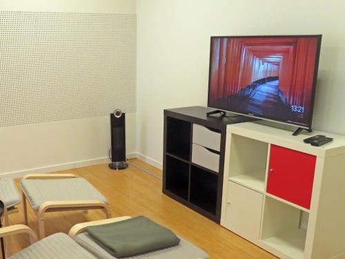 奥达巴克加塔蓝屋公寓的客厅配有壁橱上的平面电视