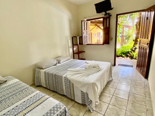 阿拉亚尔达茹达Pousada Aruanã的一间卧室设有两张床,墙上配有电视。