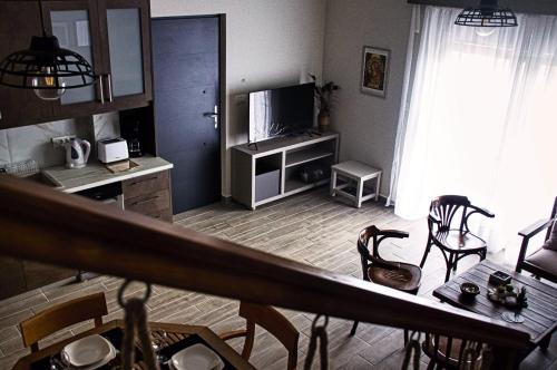 科斯镇Easy Living 1 & 2的客厅配有桌椅和电视。