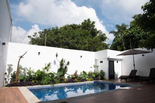 迪坡斯特兰Casa Naâmja的白色墙壁旁的带遮阳伞的游泳池