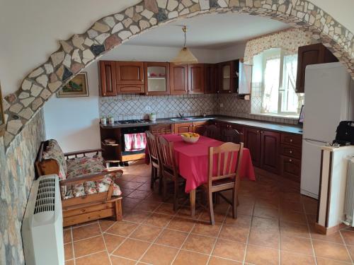 Appartamento stile rustico in collina的厨房配有带粉色桌布的桌子