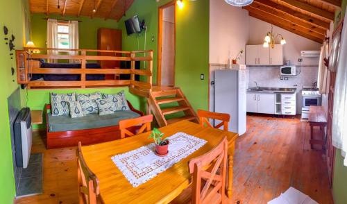 托尔胡因Cabañas Posada de las Flores的厨房以及带桌子和双层床的用餐室。