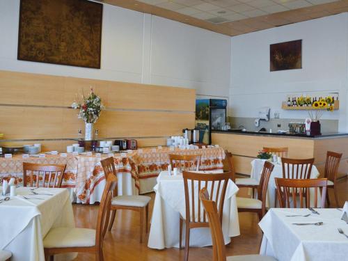 圣地亚哥Hotel Nippon y Centro de Eventos的用餐室配有桌椅和白色的桌布