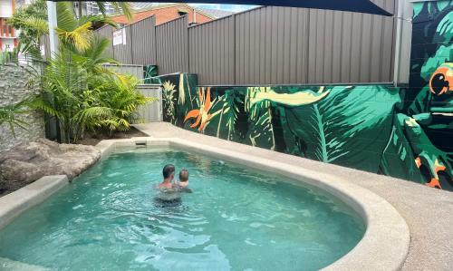 楠伯南博高地汽车旅馆的在带有壁画的游泳池游泳的人