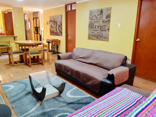 阿亚库乔Duplex amoblado en el corazón de Ayacucho的客厅配有沙发和桌子