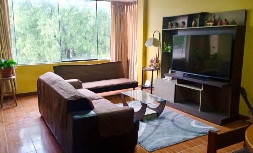 阿亚库乔Duplex amoblado en el corazón de Ayacucho的带沙发和电视的客厅