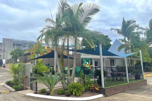 楠伯南博高地汽车旅馆的前面有棕榈树的房子