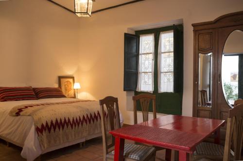 乌玛瓦卡切洛阿里巴度假屋的卧室配有床、桌子和窗户。