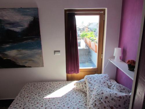 阿奇卡斯泰洛La Terrazza sul Mare的一间卧室设有一张床和一个窗口