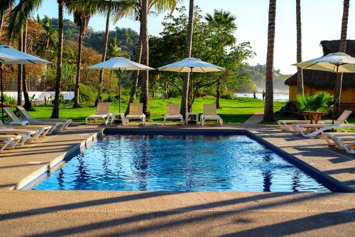 圣法兰西斯克Hotel Ysuri San Pancho的一个带椅子和遮阳伞的游泳池