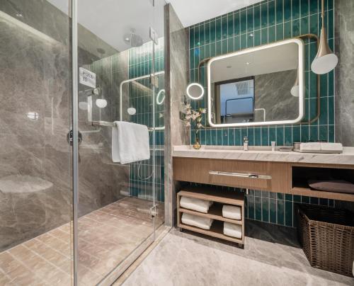 深圳深圳南山科技园希尔顿惠庭酒店的带淋浴、盥洗盆和镜子的浴室