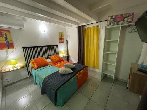 圣吕斯Kaza Mango的一间卧室配有带橙色枕头的床