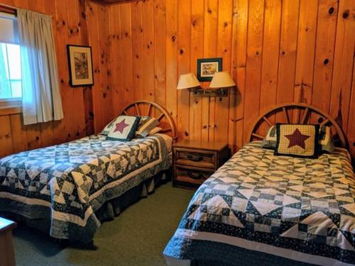 StrawberryCabin #5的一间卧室设有两张床和木墙