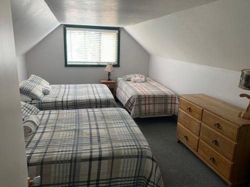 StrawberryCabin #6的一间卧室设有两张床、一个梳妆台和窗户。