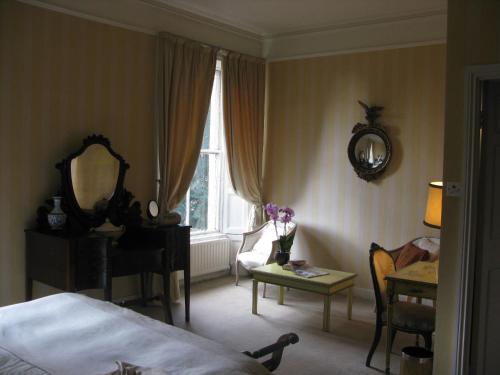 科克Flemings Country House的一间卧室配有一张床、一张桌子和一面镜子