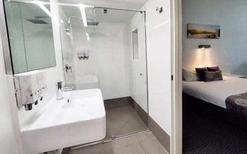 洛坎普顿阿彻公园汽车旅馆的白色的浴室设有水槽和一张床