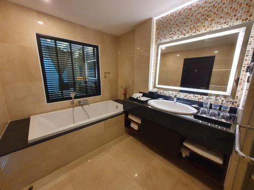 万荣Tmark Resort Vangvieng的带浴缸、水槽和镜子的浴室