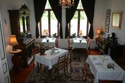 WittemHotel Beukenhorst的一间设有4张桌子和白色桌布的用餐室