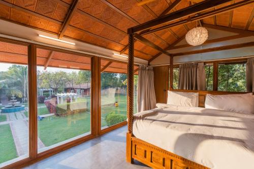海得拉巴Brown Town Resort & Spa的一间卧室设有一张床和一个大窗户