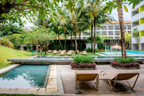 努沙杜瓦IKOSHAROLD Resort Benoa的一个带游泳池和棕榈树的度假村