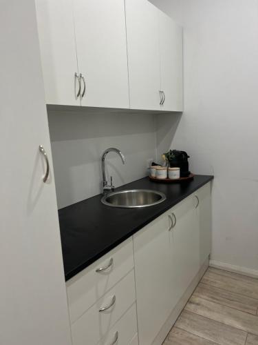 悉尼Spirit of Bondi Apartments的厨房配有水槽和白色橱柜