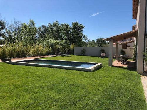 格里莫Villa neuve et moderne avec piscine à Grimaud的后院,草地上设有游泳池