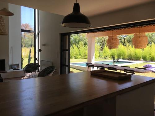 格里莫Villa neuve et moderne avec piscine à Grimaud的一个带桌子的厨房,享有游泳池的景色