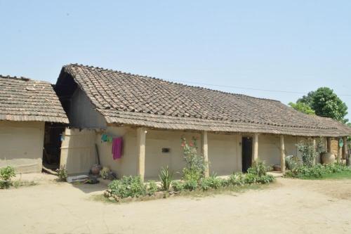 Bhada Community Homestay的村子里一座带瓷砖屋顶的老房子