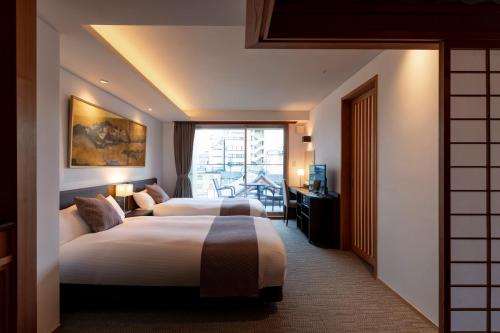 京都Rinn Gion Hanatouro的酒店客房设有两张床和窗户。