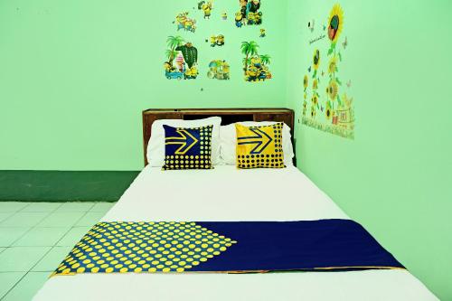 谏义里SPOT ON 92400 Dhaha Penginapan House Syariah的一张带黄色和蓝色枕头的床