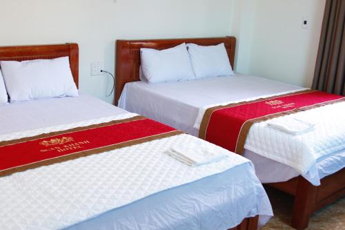 清化Biển Hải Tiến - Nhà nghỉ Ngân Khánh的两张睡床彼此相邻,位于一个房间里