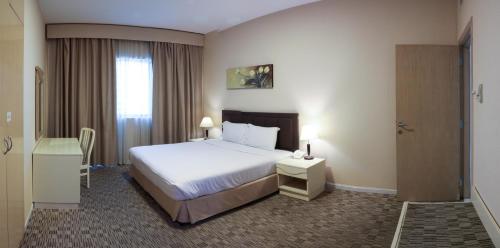 迪拜West Zone Pearl Hotel Apartment的酒店客房设有床和窗户。