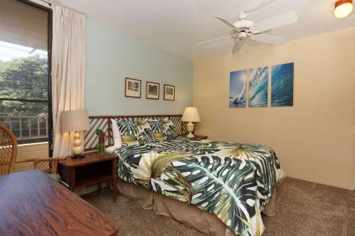 卡哈纳Paki Maui 313的一间卧室配有一张床、一张书桌和一个窗户。