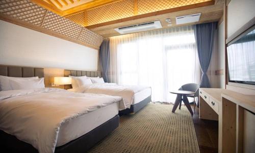 全州市Jeonju Tourist Hotel kkotsim的酒店客房设有两张床和电视。