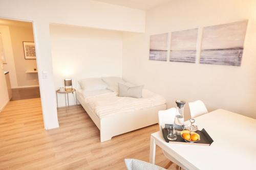不莱梅Gemütliches und helles Studio Apartment mit Balkon, Badewanne, WLAN, Parkplatz的客厅配有白色的沙发和桌子