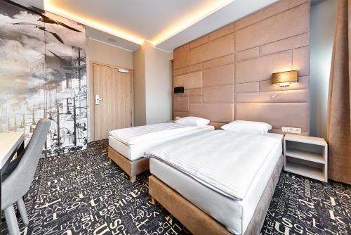 罗兹Citi Hotel's Łódź的配有壁画的酒店客房内的两张床