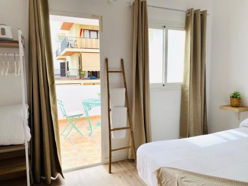 伊维萨镇巴特拉宾馆的一间卧室,卧室配有床和靠窗的梯子