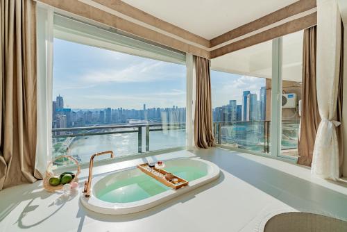 重庆重庆早安醉美江景民宿的一间位于大窗户前的带浴缸的浴室