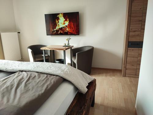 MeckelGasthaus Herrig的客房设有1张床和1张带壁炉的桌子。