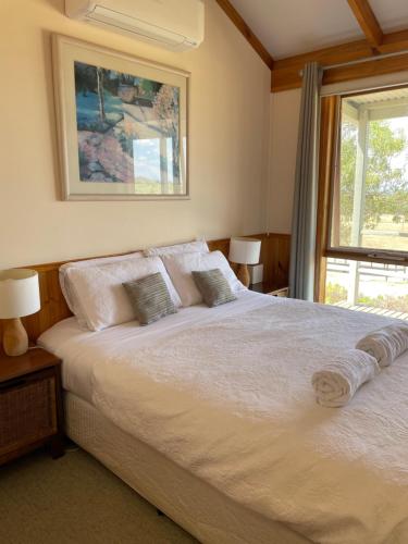 旺加拉塔瓦比农家乐的卧室配有一张大白色床和窗户