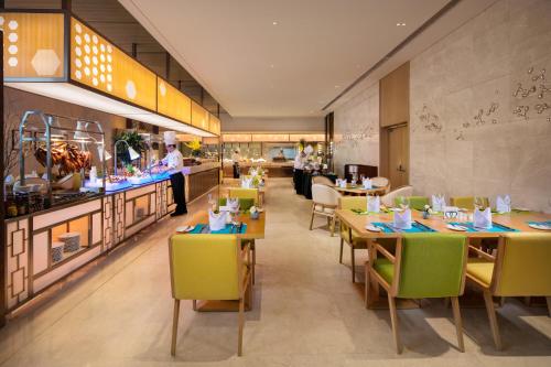 天津天津中北假日酒店的一间带桌椅的餐厅和一间厨房