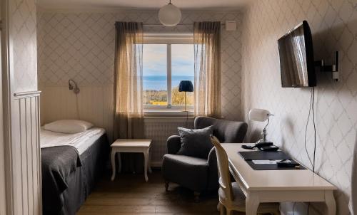 塔尔伯格Hotell Villa Långbers的配有一张床、一张书桌和一扇窗户的酒店客房