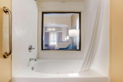 塔拉哈西Comfort Suites Tallahassee Downtown的带浴缸和镜子的浴室