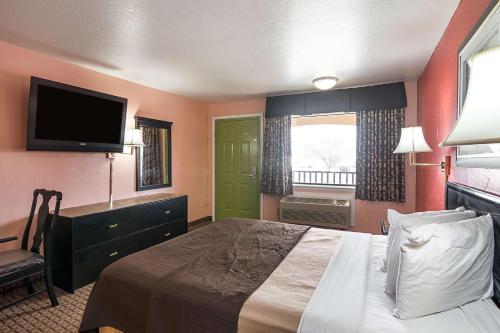 达尔哈特Econo Lodge Dalhart Hwy 54 - Hwy 287的配有一张床和一台平面电视的酒店客房