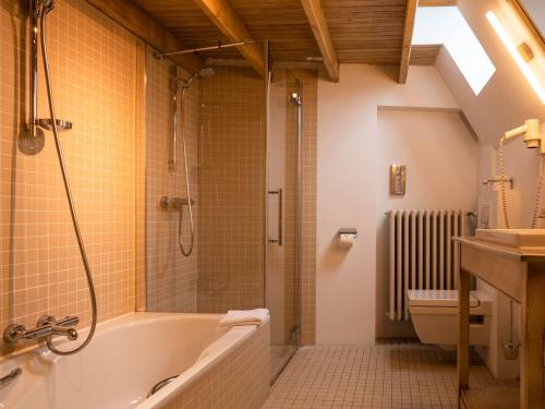 根特Hotel Monasterium PoortAckere Ghent的带浴缸、淋浴和卫生间的浴室